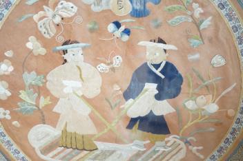 A 20th century Chinese framed embroidered figurative silk circular panel with a brocade border